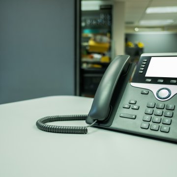 benefits phonepower voip service voip phone in office on desk servers in the background